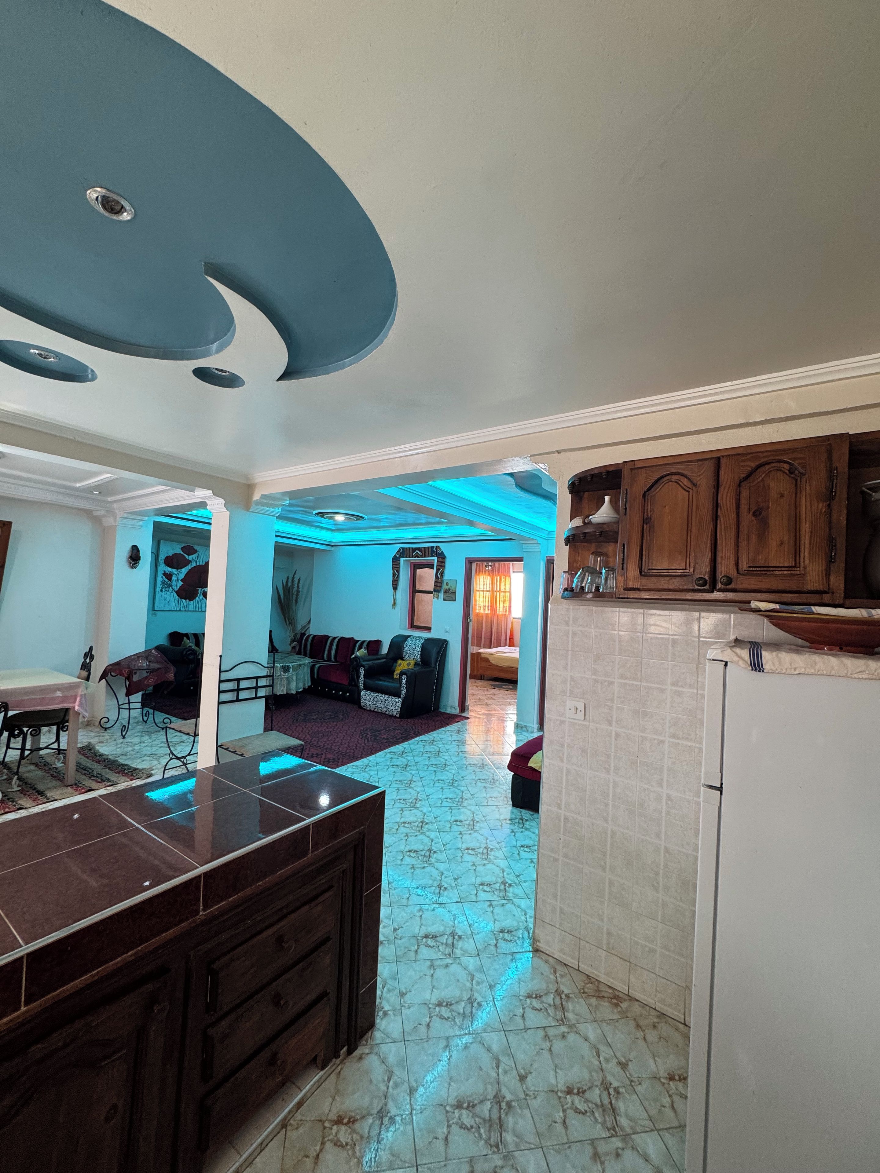 A spacious living area with a kitchen, a dining area, and a visible doorway leading to another room.