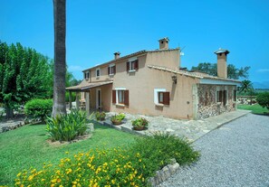 A two-story house with a stone facade, a tiled roof, and a gravel driveway. - Spacious Countryside Villa, A/C, Private Pool, Magnificent Views of s'Albufereta & Bay of Pollença! (Alcudia)
