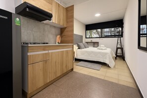 Un dormitorio pequeño con cama, mesita de noche y ventana.