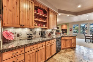 A kitchen with wooden cabinets, granite countertops, and a built-in dishwasher.