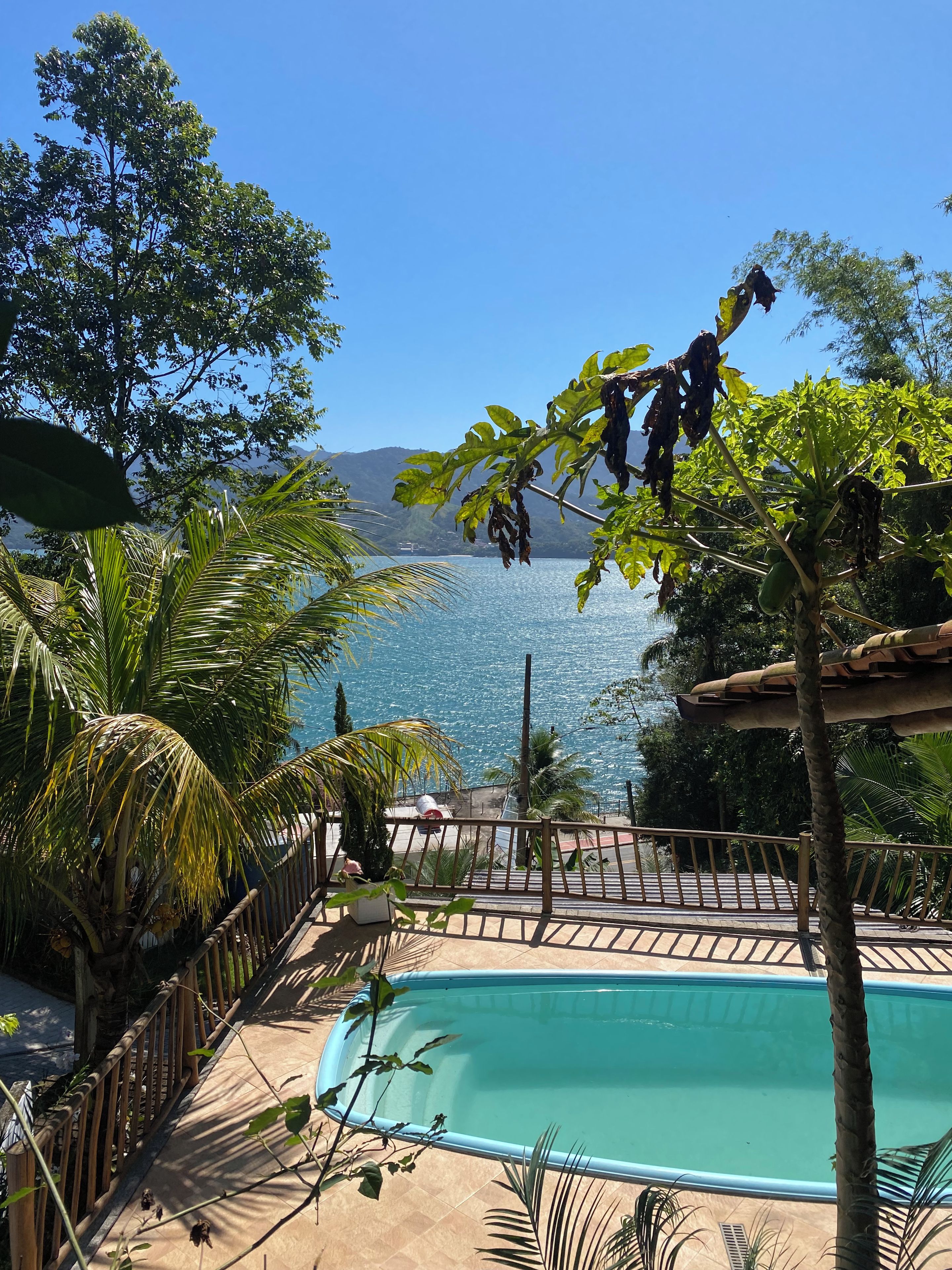 A pool area with a view of the sea and mountains.