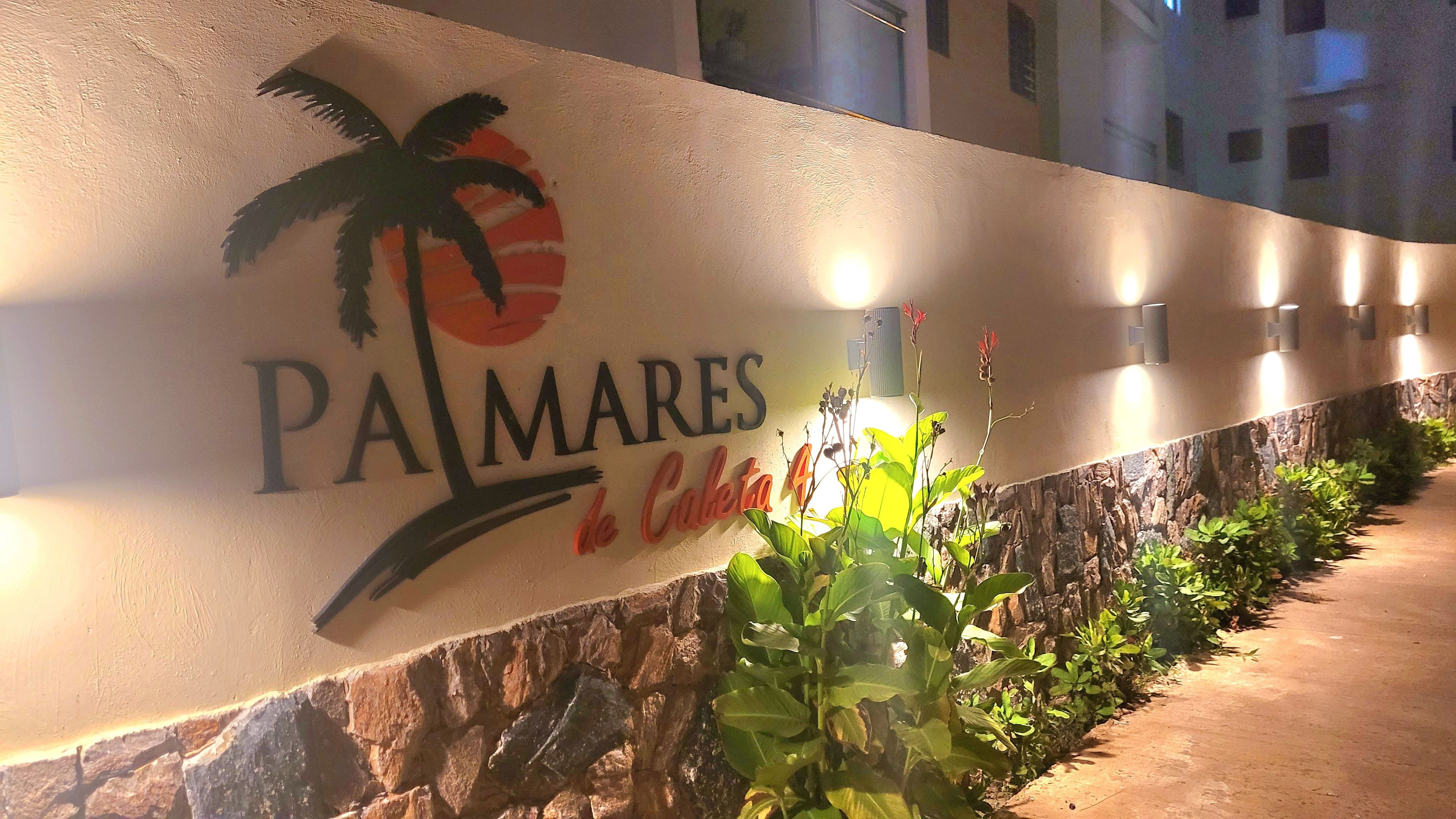 Een bord met de naam 'PA MARES' en een afbeelding van een palmboom, wat duidt op een hotel of resort.
