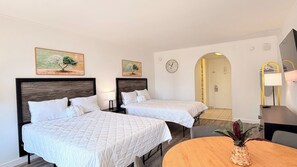 A hotel room with two beds, a round wooden table, and a plant. - 3rd Floor Beach Getaway | 2 Queen Beds (Myrtle Beach)