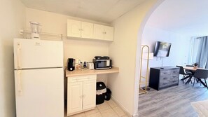 A compact kitchen with a refrigerator, microwave, and toaster. There is a small dining area with a table and chairs. - 3rd Floor Beach Getaway | 2 Queen Beds (Myrtle Beach)