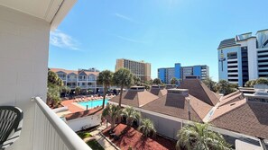 A hotel with a pool, palm trees, and a view of other buildings. - 3rd Floor Beach Getaway | 2 Queen Beds (Myrtle Beach)