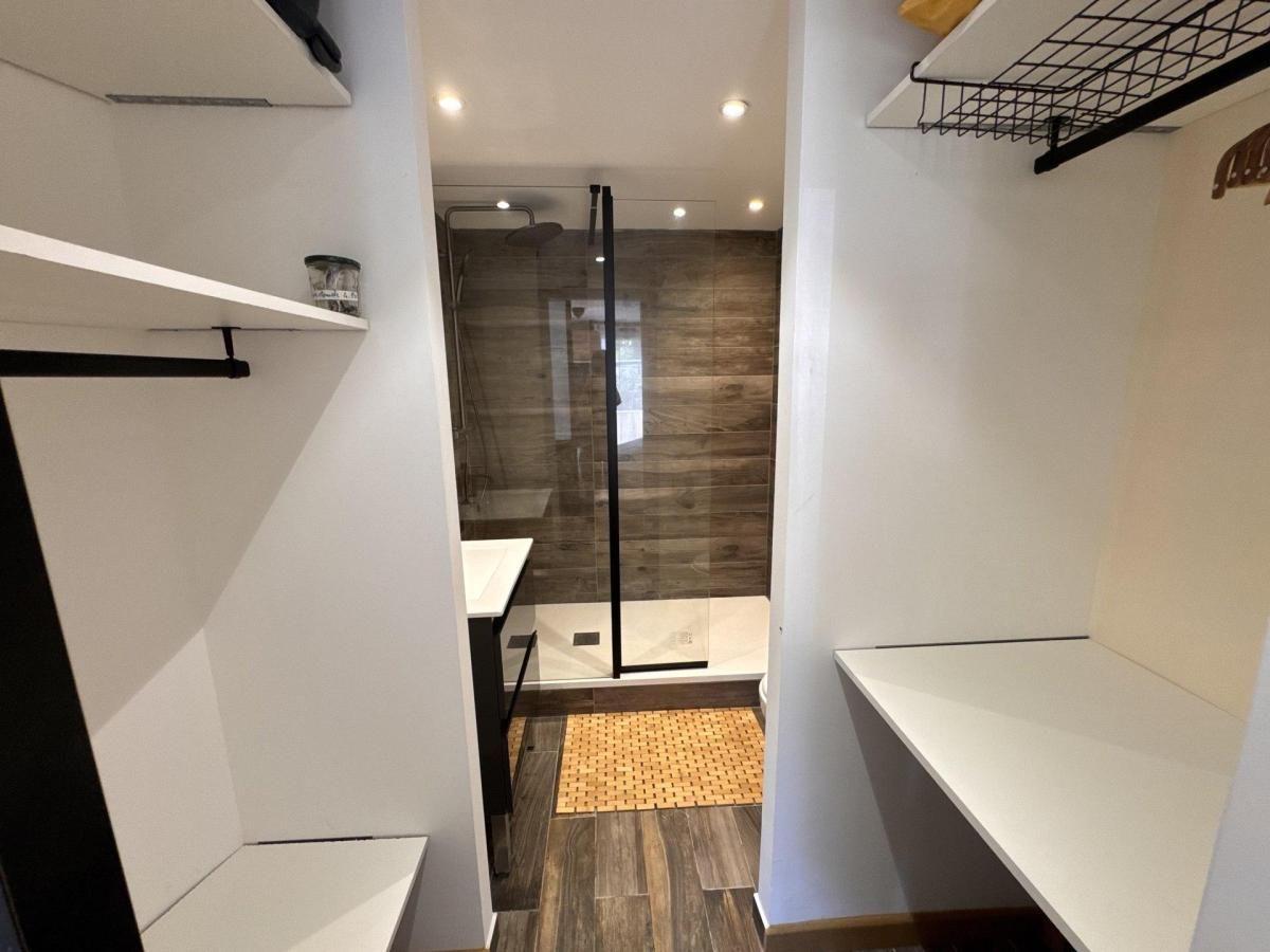 Un bagno moderno con doccia, lavandino e pavimento in legno.