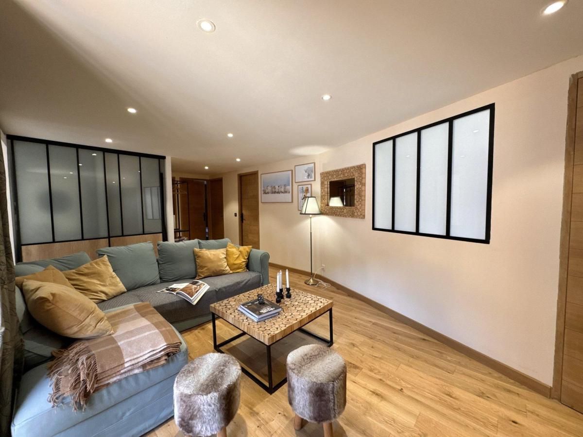 A modern living room with a sofa, coffee table, and ottomans.