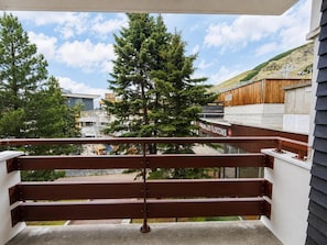 Ein Balkon mit Metallgeländer, der auf eine Baustelle und ein Gebäude mit der Aufschrift 'FENALLES FLOONS' blickt.