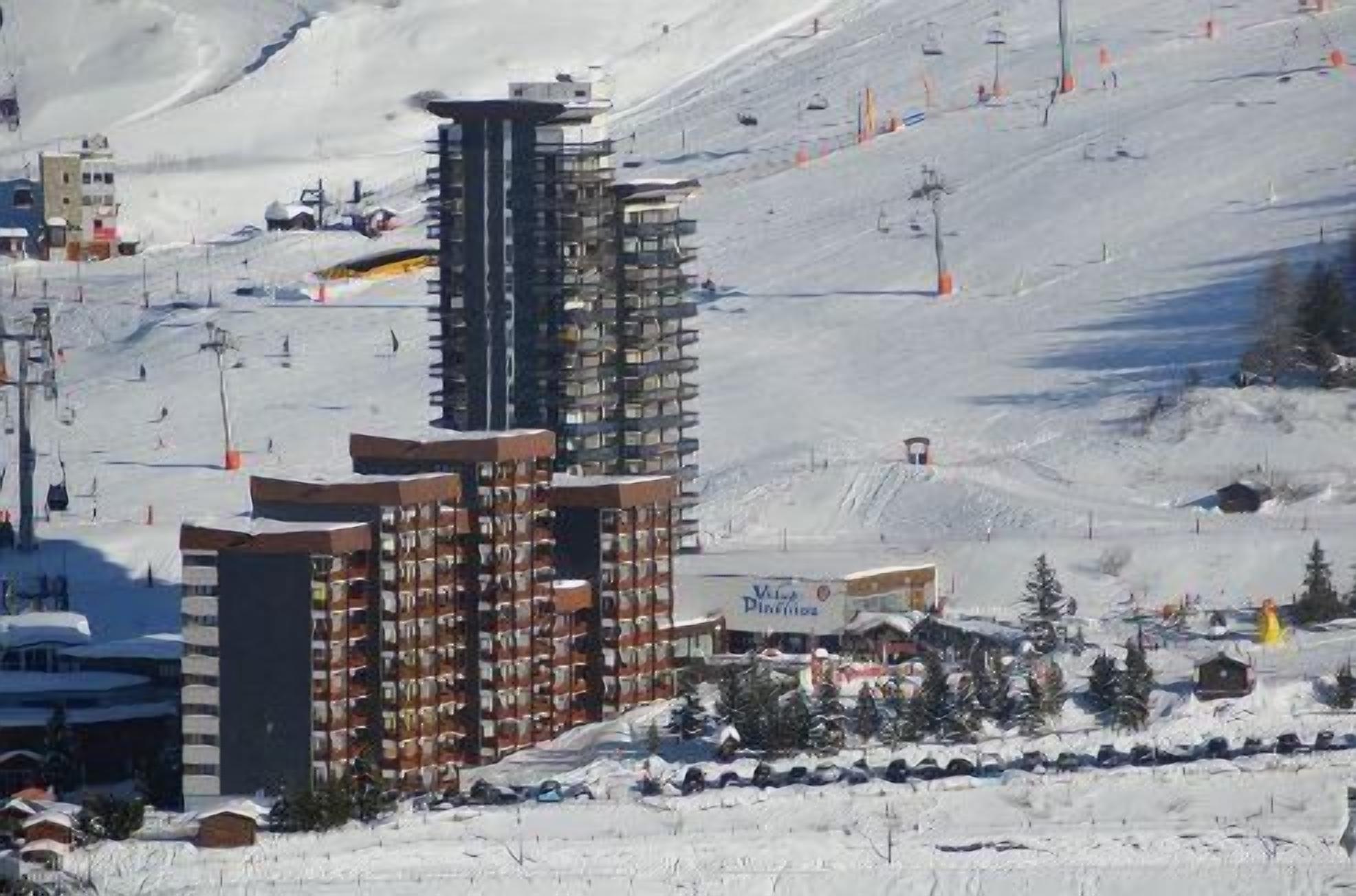 Ein mehrstöckiges Hotel mit einer Seilbahn im Hintergrund.