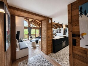Ein modernes Interieur mit Holzbalken, einer Küche und einer Sitzecke mit Blick.