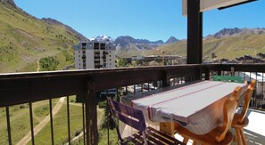 A balcony with a table and chairs, overlooking a mountainous landscape with buildings in the background. - 150m from ski lifts, 7th floor, balcony, tv, ski locker, 35m², Tignes (Tignes)