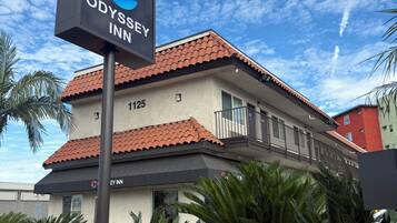 Un hotel con un cartel que dice 'ODYSSEY INN' y el número '1125' en la fachada.