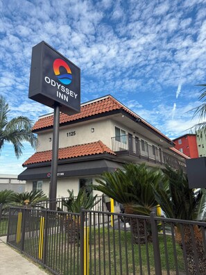 A hotel with a sign reading 'ODYSSEY INN' and a number '1125' on the building. - Odyssey Inn (National City)