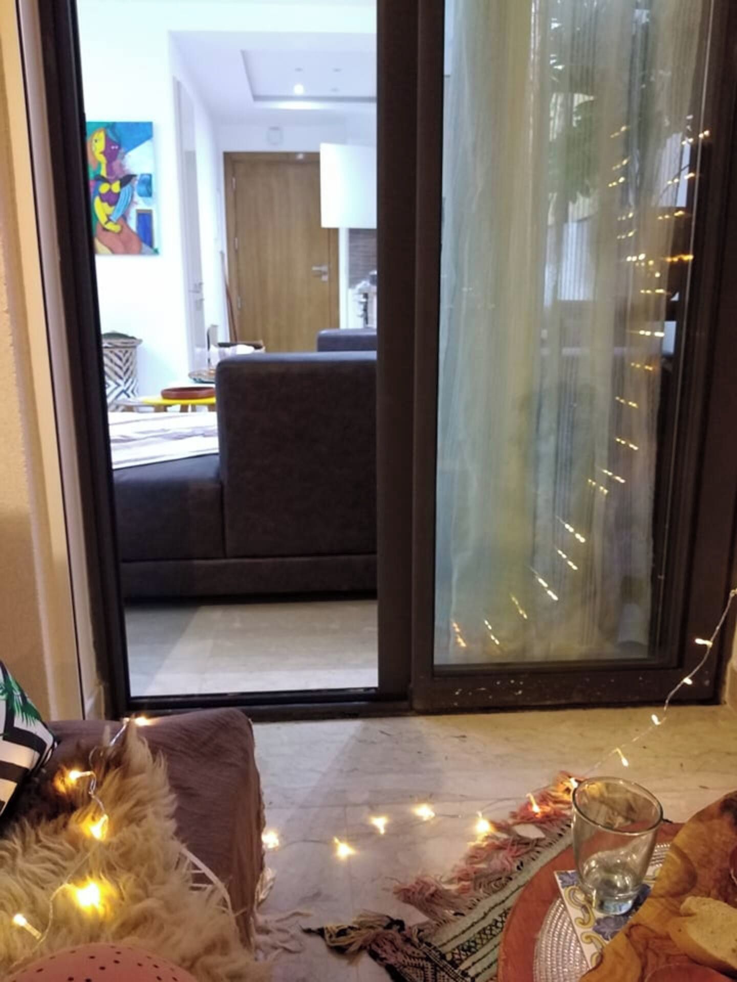 Una habitación con una puerta corredera de vidrio que da a una sala de estar con sofá y mesa de centro.