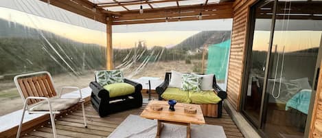 A covered outdoor seating area with a view of the landscape.