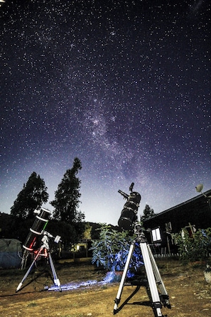 A telescope setup in an outdoor area with a clear night sky.