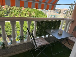 A balcony with a table, a chair, and a small plant. - Sun & Beach in the Heart of Torrevieja (Torrevieja)