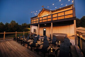 A wooden deck with outdoor seating and string lights.
