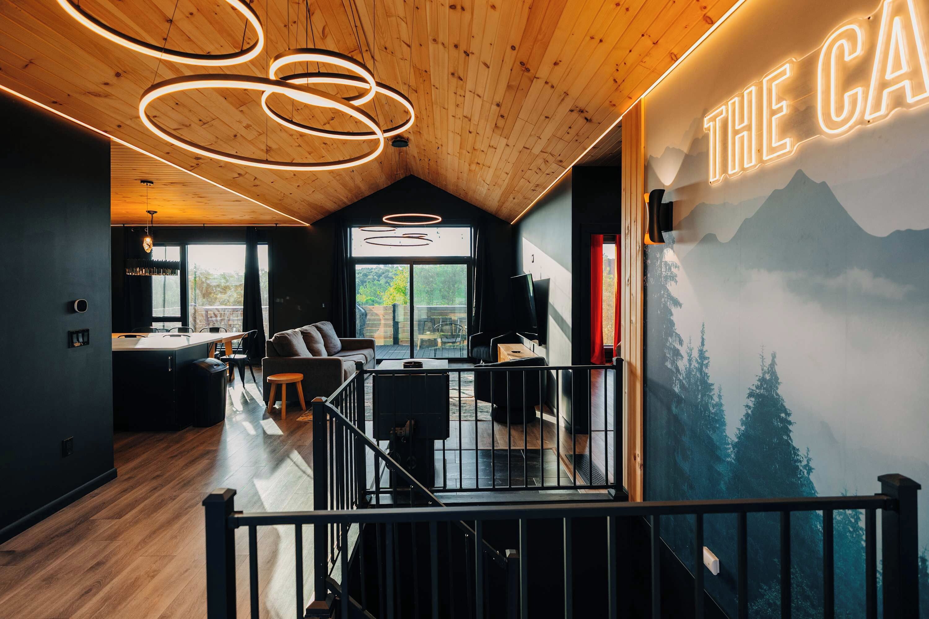 A modern interior with a wooden ceiling, a dining area, a living space, and a view of the outdoors.
