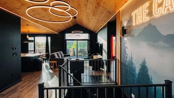 A modern interior with a wooden ceiling, a dining area, a living space, and a view of the outdoors.