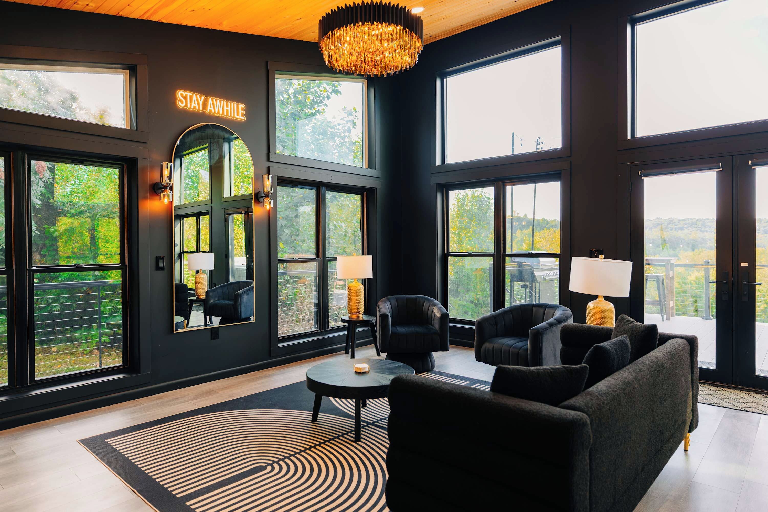 A modern interior with large windows, a chandelier, and a 'STAY AWAY' sign.