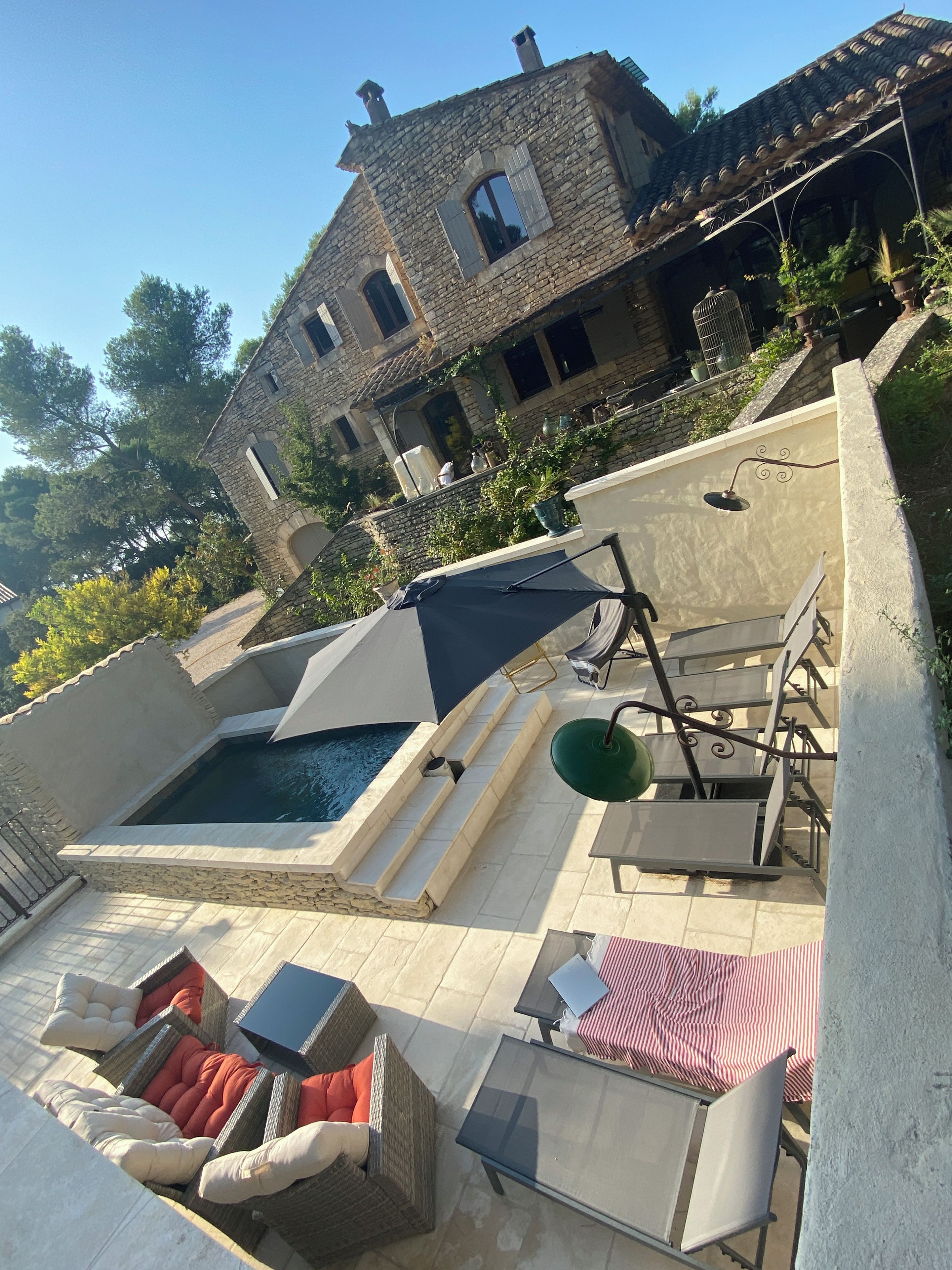 A rooftop pool area with lounge chairs and a pergola.