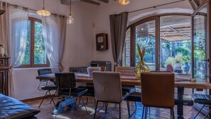 A dining area with a table, chairs, and a view of the outdoors. - 🌿 La Bastide de la Colline, an authentic Provençal house with a private pool. (Cavaillon)