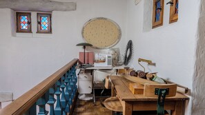 Una habitación con una máquina de coser, un espejo redondo y una mesa de madera con diversos materiales de costura.