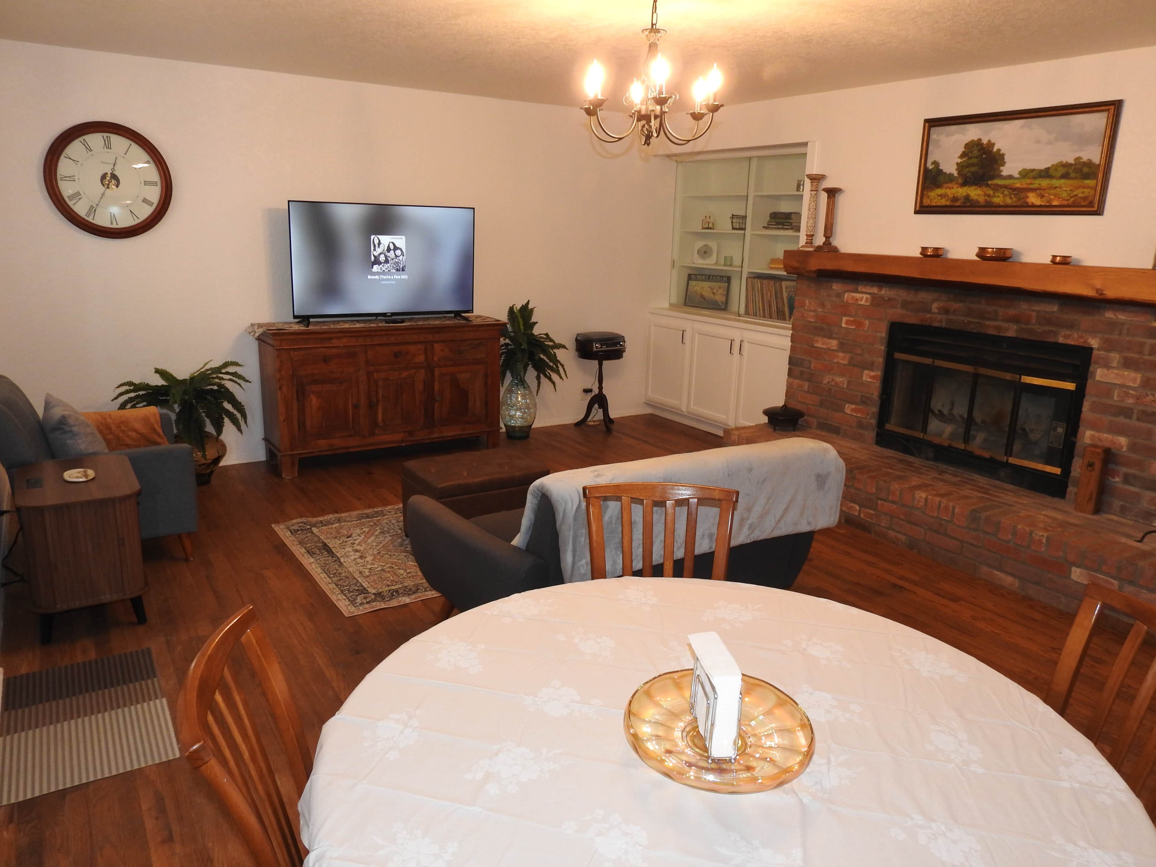 A living room with a television, fireplace, dining table, and seating area.