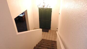 A staircase with carpeted steps leading to a door with a green door frame.