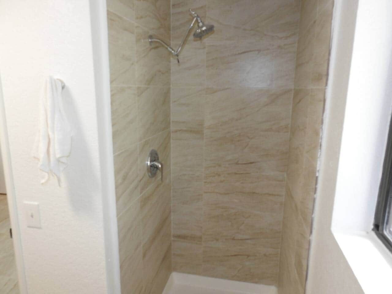 Ducha con cabezal de ducha de mano y grifo empotrado.