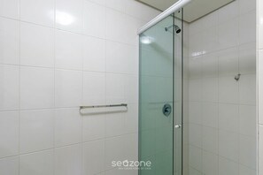 A modern bathroom with white tiles, a glass shower enclosure, and a visible towel rack. - Apt. w/ Balcony and Priv. BBQ Mtza0204 (Porto Alegre)