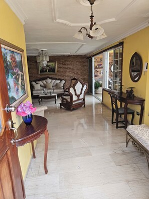 Un salon spacieux avec un canapé, une chaise en bois et une table à manger.