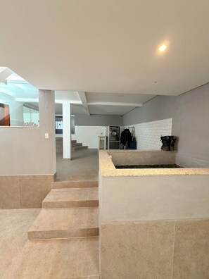 A modern interior with a laundry area, a staircase, and a view of a balcony.
