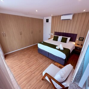A bedroom with a bed, a nightstand, a chair, and a wardrobe.