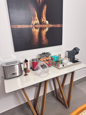 A white table with a toaster, a kettle, a thermos, and a tray with snacks and a teapot. - Country house with heated pool in the heart of Cantareira, 30 minutes from São Paulo. (Caieiras)