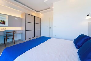 A bedroom with a bed, a desk, a chair, and a wardrobe.