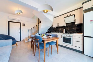 Una cocina moderna con comedor, una escalera y una sala de estar con sofá.