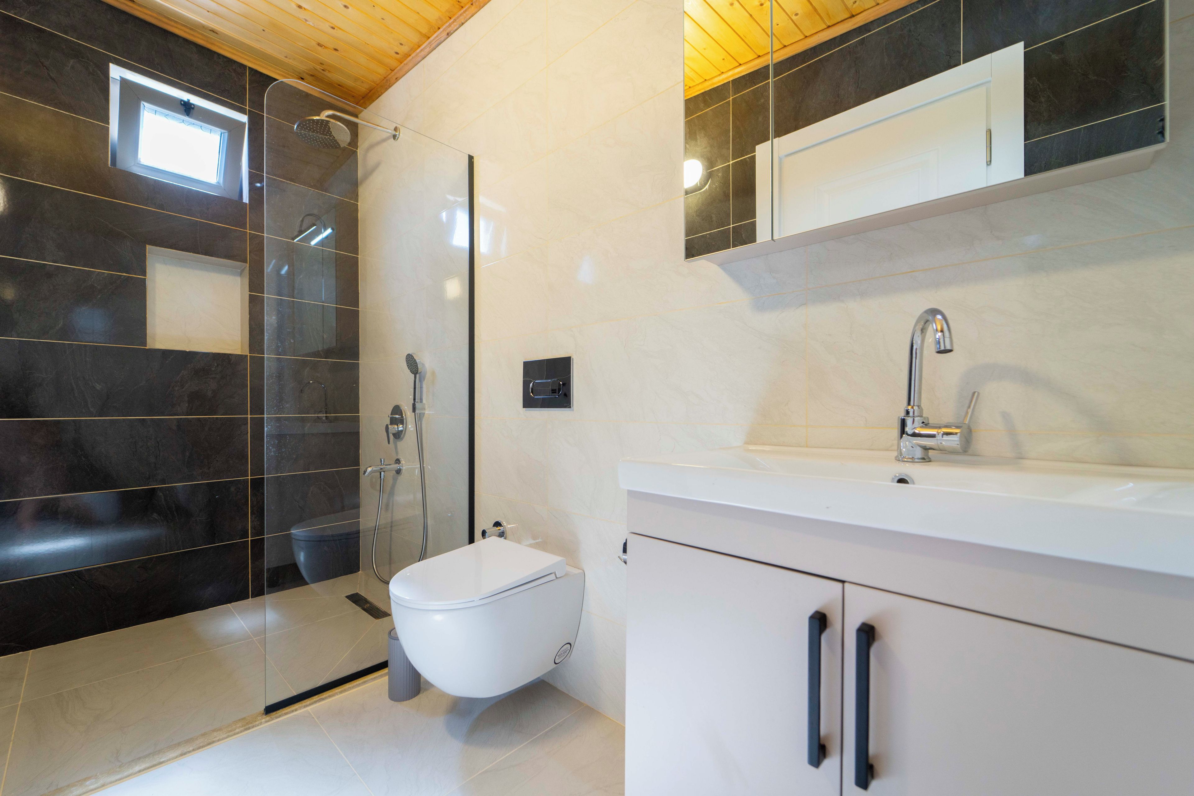 A modern bathroom with a shower, toilet, and sink.