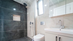 Un baño moderno con ducha, inodoro y lavabo.
