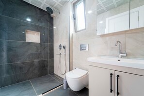 Ein modernes Badezimmer mit Dusche, Toilette und Waschbecken.