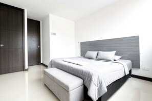 Une chambre à coucher moderne avec un lit, un banc et une armoire.