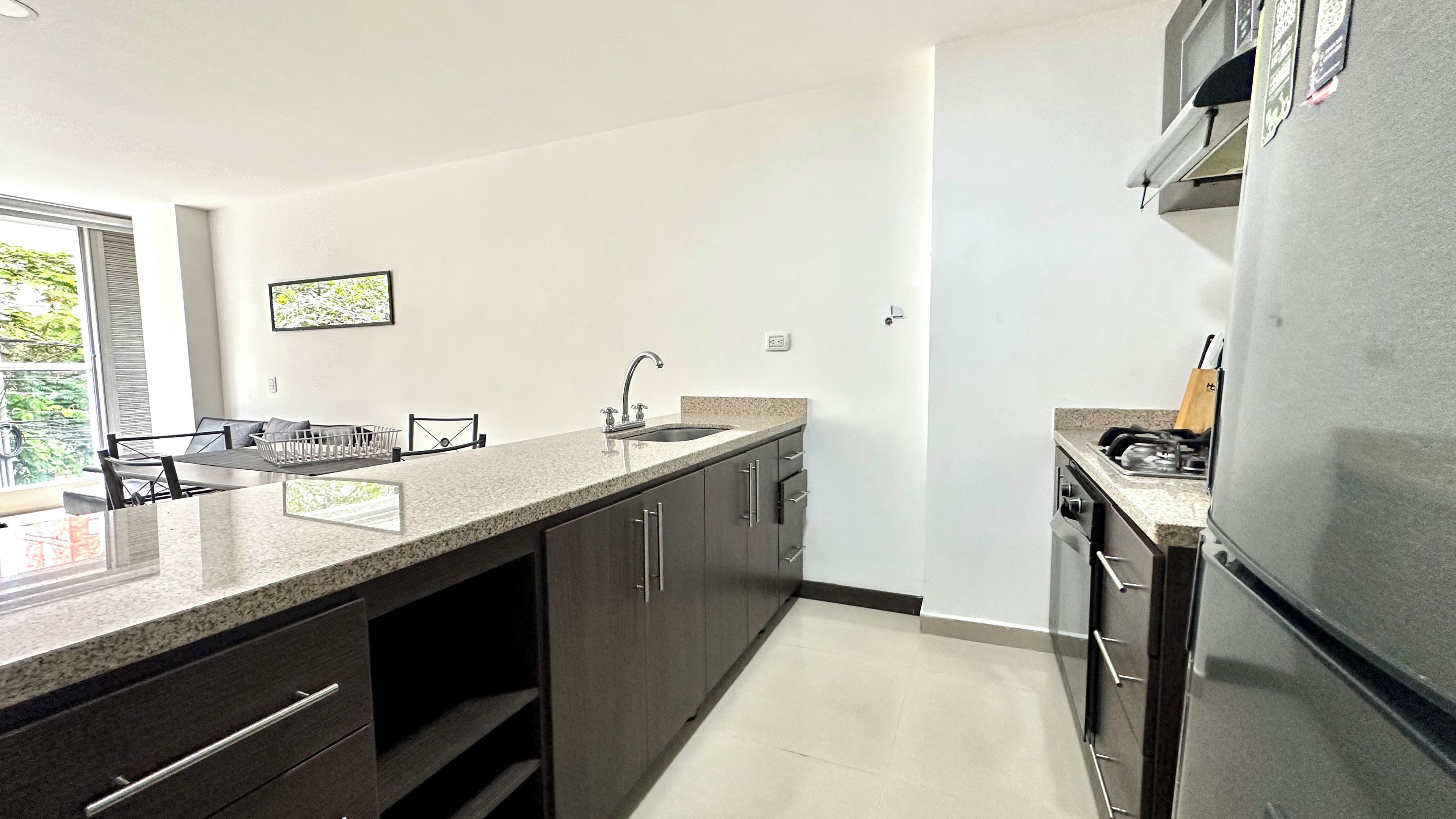 A modern kitchen with a granite countertop, stainless steel appliances, and a built-in oven.