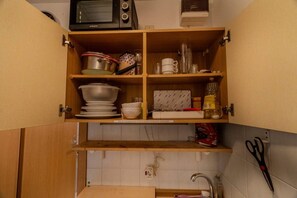 A kitchen with wooden cabinets, a microwave, a sink, and various kitchen utensils. - Idyllic 1-bedroom apartment, sauna, national park, parking (Zwiesel)
