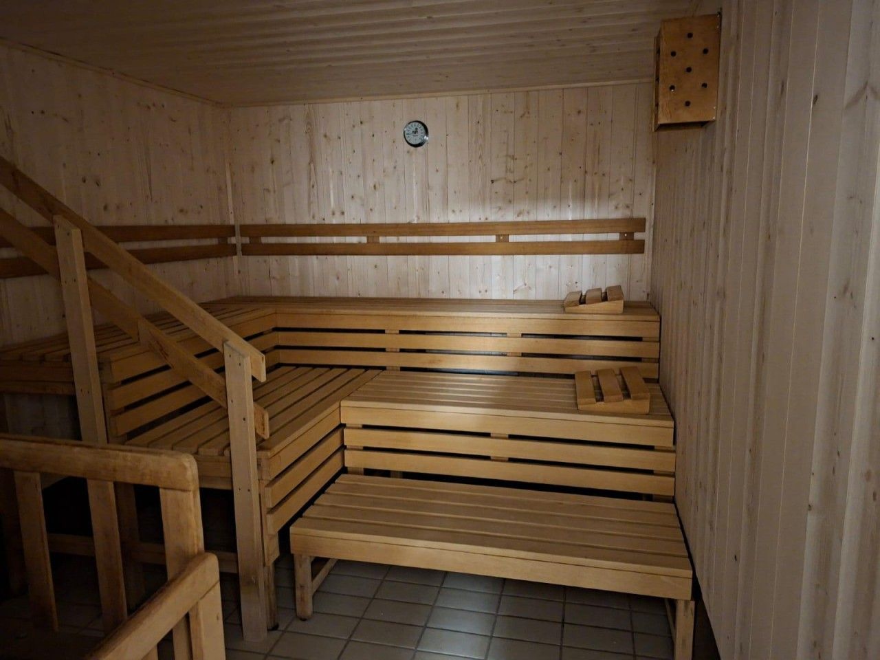 A sauna with wooden benches and a sloped ceiling.