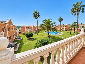 A hotel courtyard with a swimming pool, palm trees, and a well-maintained lawn. - Oliva Nova MET & Beach - Apartment for 4 people, 400 m from the beach and 50 MET from the Costa Blanca (VC)