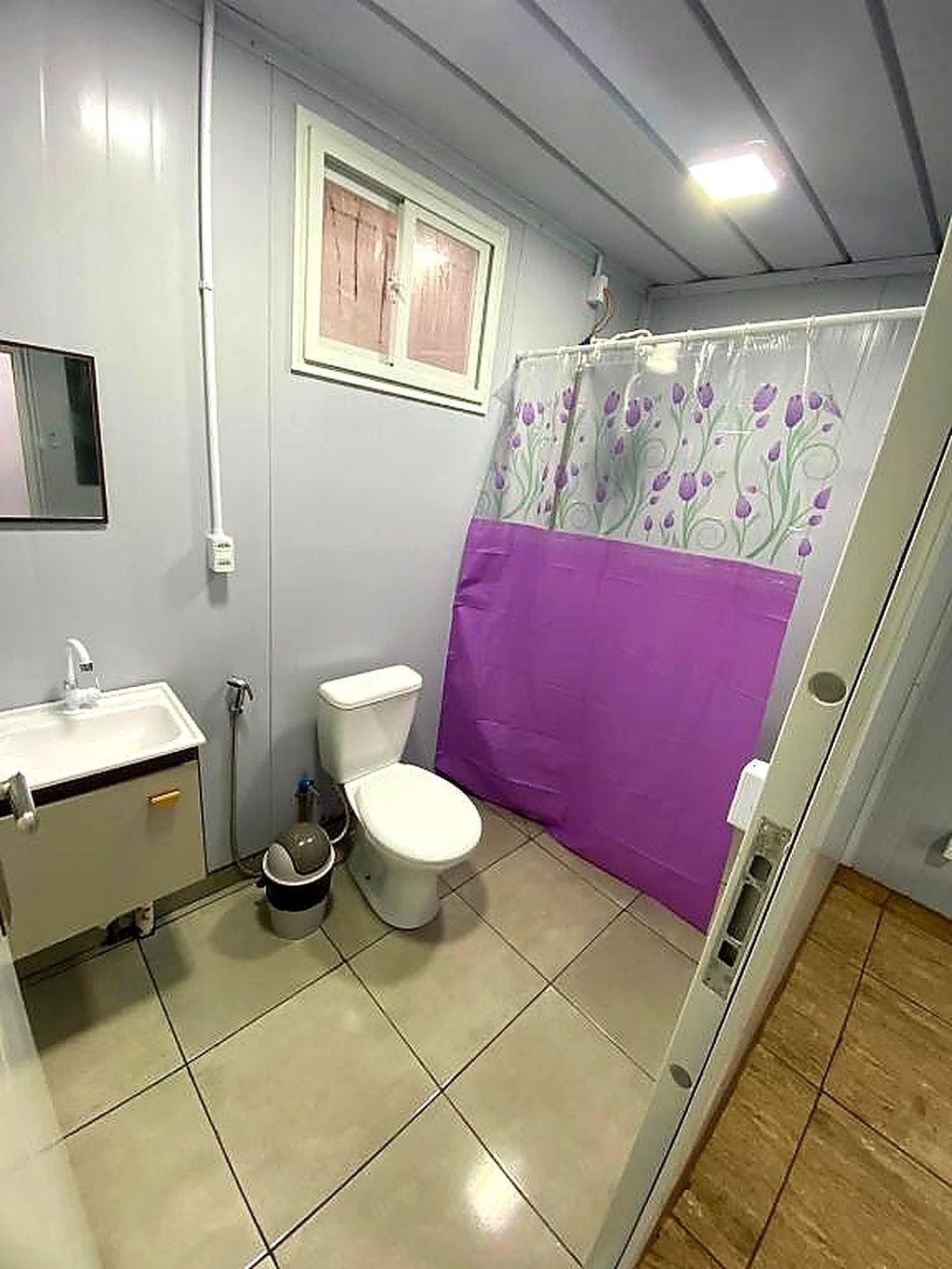 Une salle de bain avec des toilettes, un lavabo et un rideau de douche.