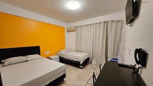 Habitació d'hotel amb dos llits, un escriptori, una televisió i un telèfon.