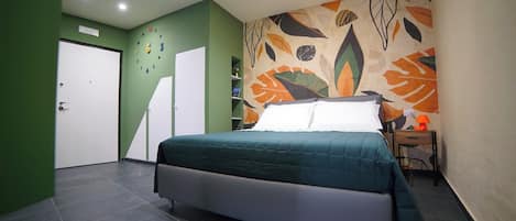 Un dormitorio con cama, armario, mesita de noche y pared con diseño de hojas.