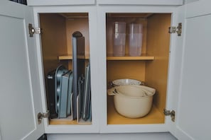 Een kastje met keukengerei en opbergbakken.